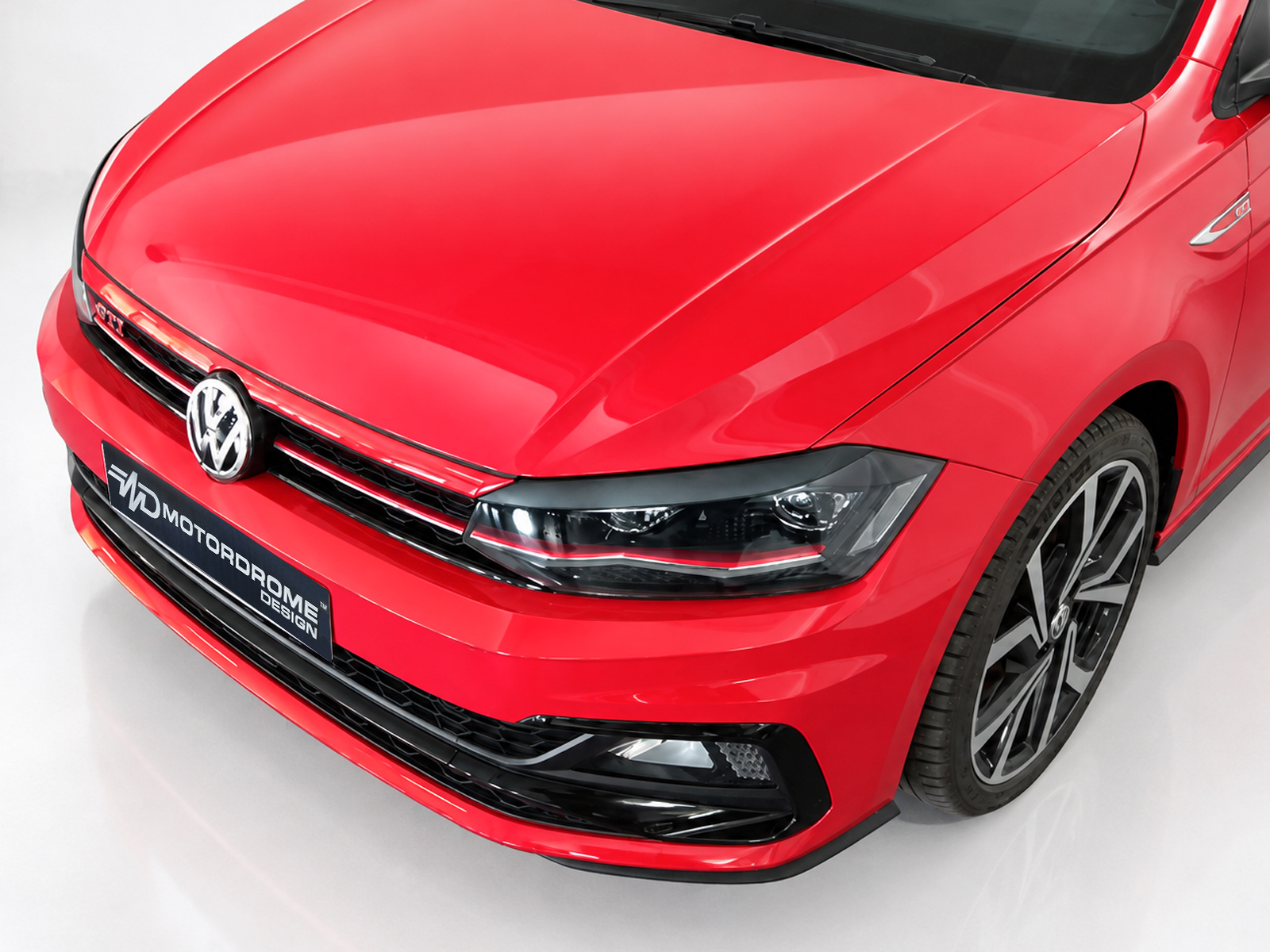 FR000157_1jpg - OPSHOLDERS Red Volkswagen car front end with emblem, headlight, and large alloy wheel visible on the right.