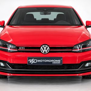 FR000157_2jpg - OPSHOLDERS Front view of a red Volkswagen GTI in a studio setting, showing the honeycomb grille, VW emblem, and sharp headlights.