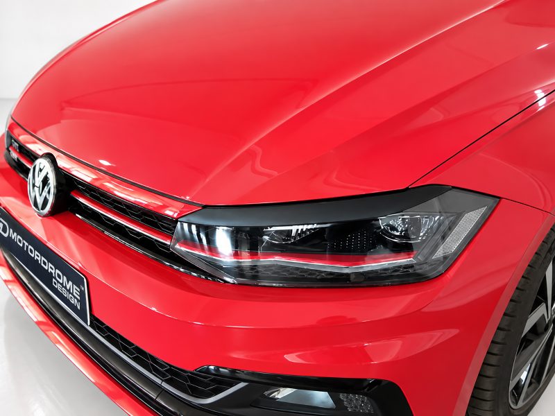 FR000157_3jpg - OPSHOLDERS Front-left detail of a red Volkswagen car, featuring the emblem, grille, and headlight close-up.