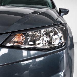 Close-up of the front left headlight and fender of a dark blue/gray sedan.
