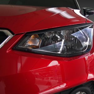 Close-up of the front end, showing the red car's headlight and bumper