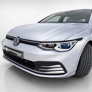 Front-left view of a silver Volkswagen sedan in a studio setting, license plate reading MOTORDROME DESIGN far below the grille.