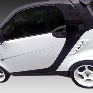 White compact two-seater car (Smart Fortwo) with black roof on a gray gradient background.