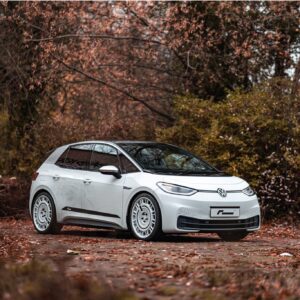 ID3-Lowering-Springs-1jpg - OPSHOLDERS White VW SUV parked on a leaf-strewn path with orange autumn foliage in the background.
