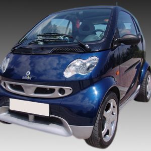 Blue Smart car photographed from a front-left angle, showing compact design and shiny finish.