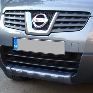 Front view of a gray Nissan SUV grille with chrome emblem and a blue Greek license plate (GR) visible on the bumper area.