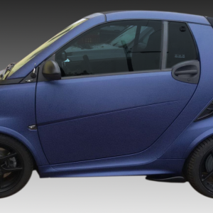 Side view of a blue compact hatchback with black wheels and tinted windows, showing a two-door design and a small rear spoiler