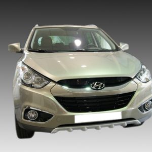 Front view of a silver Hyundai SUV, grille with logo, headlights, and fog lights against a gradient background.