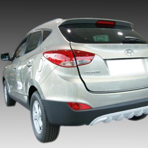 Rear view of a silver Hyundai SUV, showing taillights, rear bumper, and blurred license plate on a gradient background.