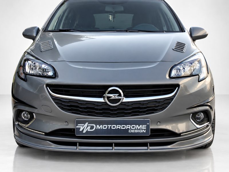 Front view of a silver Opel car showing headlights, grille with emblem, and bumper detail. Plate reads MD MotorDrome Design (brand display).