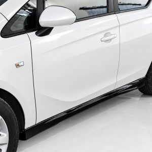 Close-up of a white car's side, showing the front wheel, doors, side mirror, and side running board.