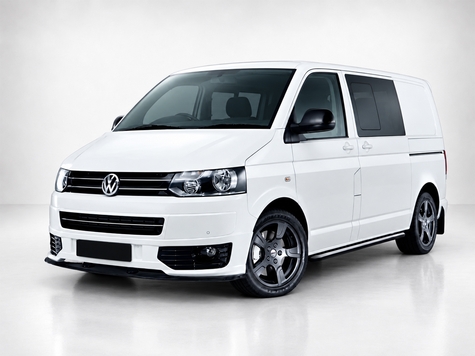 K147-001_1jpg - OPSHOLDERS White Volkswagen van photographed from front-right in a studio setting, showing its black grille and alloy wheels.