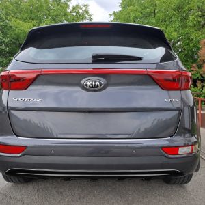 Rear view of a dark gray Kia Sportage SUV parked outdoors, showing tail lights, rear hatch, and CRDi badge.