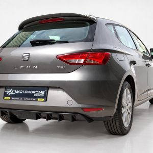 Rear view of a gray SEAT Leon TSI hatchback in a studio, with red tail lights and a sporty diffuser.