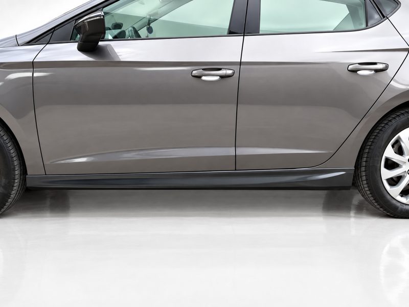 Side view of a gray sedan showing the front and rear doors, lower body line, and wheel on the right side.