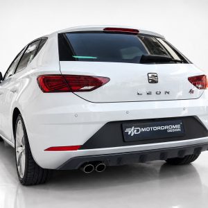 Rear view of a white SEAT Leon FR hatchback in a studio setting, showing the taillights and dual exhausts.
