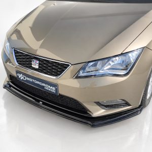 K150-007_2jpg - OPSHOLDERS Front three-quarter view of a metallic beige car facing left, showing a honeycomb grille with a small badge, sharp headlight, and a black lower front splitter with a motorsport-style plate reading MOTORDROME DESIGN