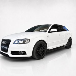 K151-004_2jpg - OPSHOLDERS White Audi sedan in a three-quarter front view with black multi-spoke wheels, photographed in a bright studio on a glossy floor.