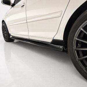K151-004_3jpg - OPSHOLDERS Close-up of a white car's lower side panel and large black alloy wheel with red brake caliper visible behind it.