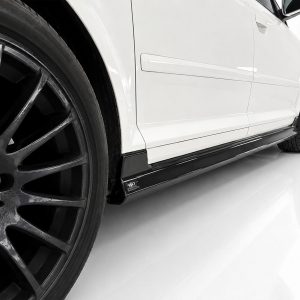 K151-004_4jpg - OPSHOLDERS White car side close-up with large black alloy wheel and sleek side skirt, Audi emblem on the rim visible
