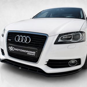 Front view of a white Audi sedan with a black grille, chrome trim, and prominent four-ring emblem on the grille.