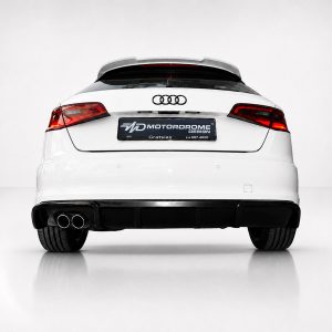 Rear view of a white Audi car in a studio setting, showing the Audi logo and a black license plate with MOTORDROME DESIGN branding.