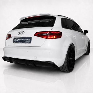 Rear three-quarter view of a white Audi station wagon with a sport rear diffuser and dark alloy wheels in a studio setting.