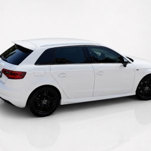 K152-003_4jpg - OPSHOLDERS White station wagon with black alloy wheels viewed from the rear-right in a bright studio setting, glossy floor reflections visible.