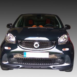 K154-001_2jpg - OPSHOLDERS Front view of a dark compact car facing the camera, with a chrome grille and orange seats visible through the windshield.