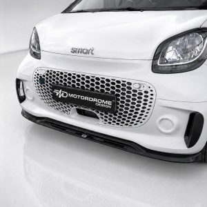 K154-004_4jpg - OPSHOLDERS Front view of a white Smart car with a honeycomb grille and a Motordrome Design plate.