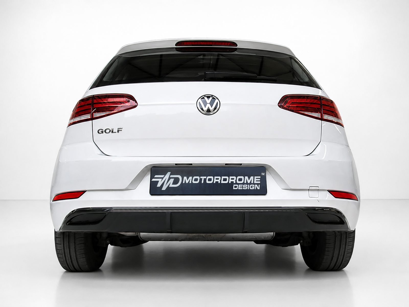K156-002_2jpg - OPSHOLDERS Rear view of a white Volkswagen Golf with red taillights and a Motordrome Design license plate.