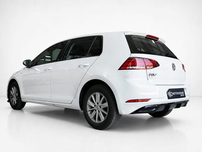 K156-002_3jpg - OPSHOLDERS White Volkswagen Golf hatchback photographed from the rear three-quarter angle in a studio setting, showing the VW badge and taillights.