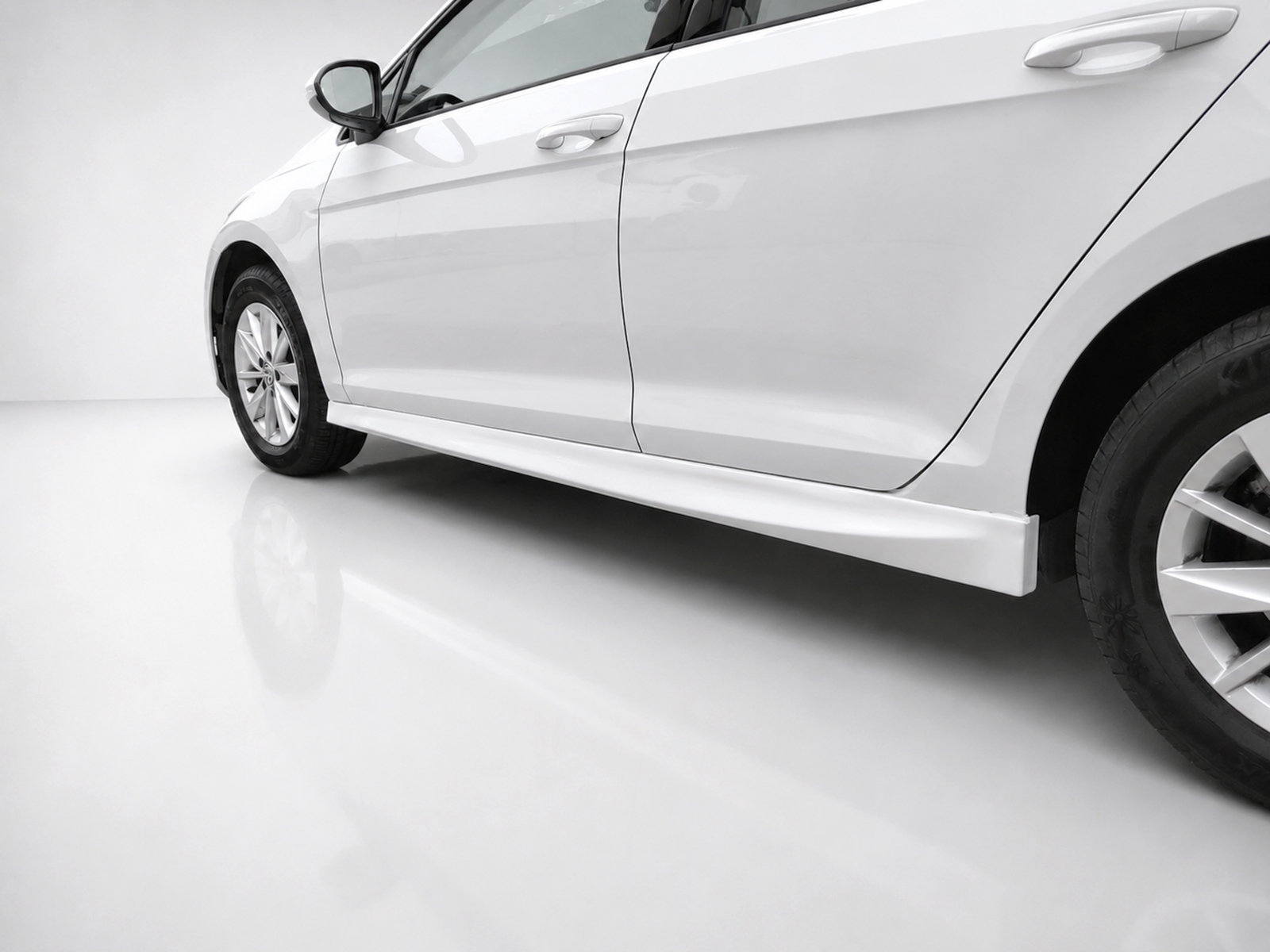 K156-003_2jpg - OPSHOLDERS Side view of a white car highlighting the lower door panel and side skirt near the wheels in a bright studio setting.