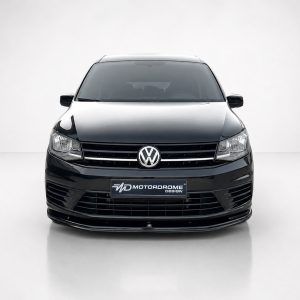 Front view of a black Volkswagen car in a studio, with the VW badge centered on the grille and a Motordrome Design plate below.