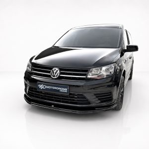 Front three-quarter view of a glossy black VW van in a clean studio setting, chrome grille visible with Motordrome Design plate at the bumper.