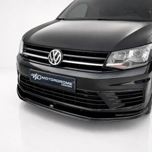 Close-up of the front of a black Volkswagen van with chrome grille and emblem in a studio setting.