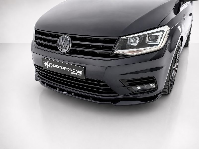 Front view of a black VW car with a bold grille and modern headlight design, displaying a Motordrome Design plate on the bumper