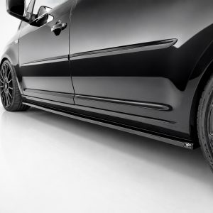 K157-003_3jpg - OPSHOLDERS Close-up of a glossy black car's side, showing the front wheel, door, and side skirt with alloy rims in sharp detail.