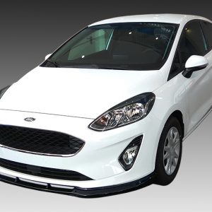 White Ford compact hatchback photographed from a front three-quarter angle, showing the grille, headlights, and side mirrors against a gray gradient background in studio lighting.