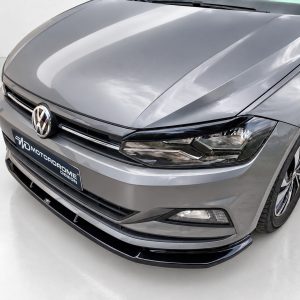 K162-001_3jpg - OPSHOLDERS Front view of a gray Volkswagen, showing the emblem and a MOTODROME DESIGN plate on the bumper.