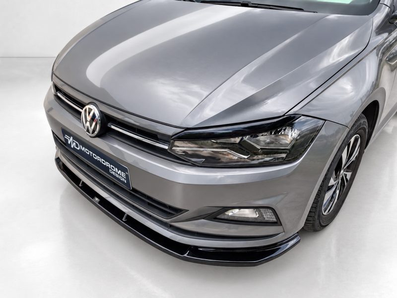 K162-001_3jpg - OPSHOLDERS Front view of a gray Volkswagen, showing the emblem and a MOTODROME DESIGN plate on the bumper.