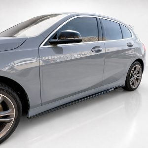 Side view of a gray luxury BMW sedan with alloy wheels and tinted windows on a light showroom floor