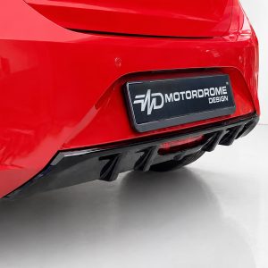 Rear view of a shiny red car showing a black license plate that reads MOTORDROME DESIGN.