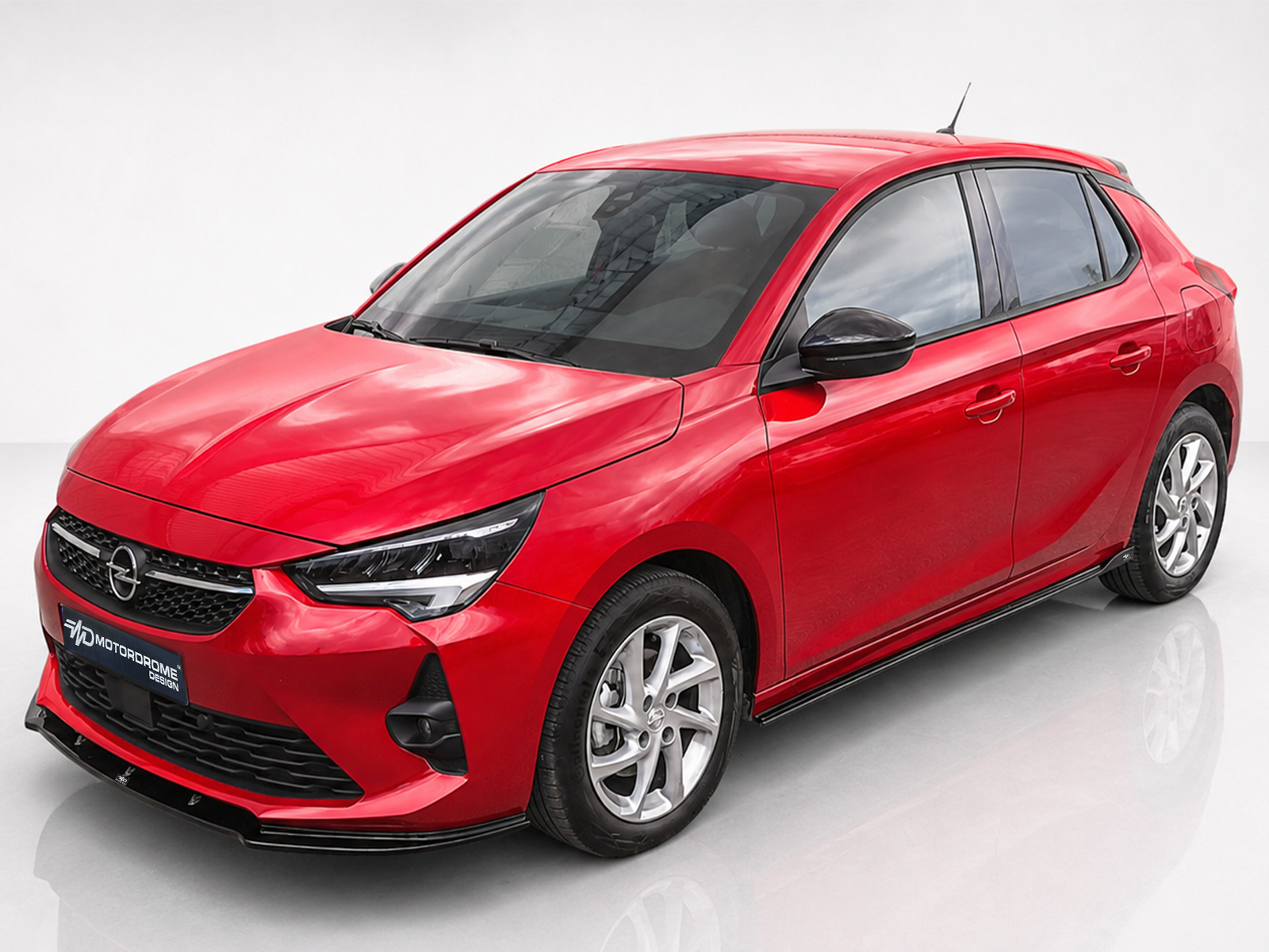 K163-003_1jpg - OPSHOLDERS Red Opel hatchback photographed in a studio, angled front-left view showing the grille, headlights, and alloy wheels.