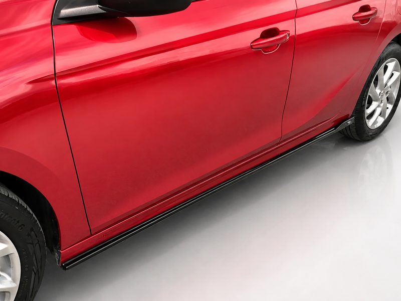 K163-003_3jpg - OPSHOLDERS Red car side with two doors, black rocker trim, and a visible silver wheel along the bottom edge of the image.