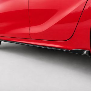 K163-003_4jpg - OPSHOLDERS Close-up of a red car's lower side panel and side skirt with a black logo tag near the wheel.