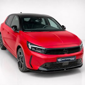 K163-006_2jpg - OPSHOLDERS Front-right view of a red hatchback with black roof in a white studio backdrop.