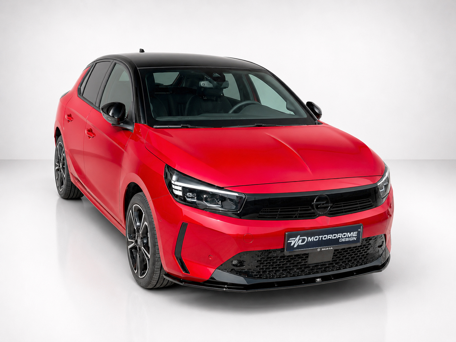 K163-006_2jpg - OPSHOLDERS Front-right view of a red hatchback with black roof in a white studio backdrop.