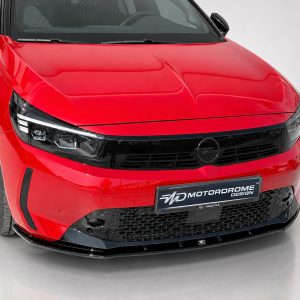 K163-006_3jpg - OPSHOLDERS Red sedan front view with black grille and Opel emblem, showroom floor setting, angled toward the right side of the image