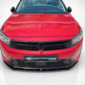 K163-006_5jpg - OPSHOLDERS Front view of a red car showing its grille, headlights, and Opel emblem in a showroom setting (high gloss finish).